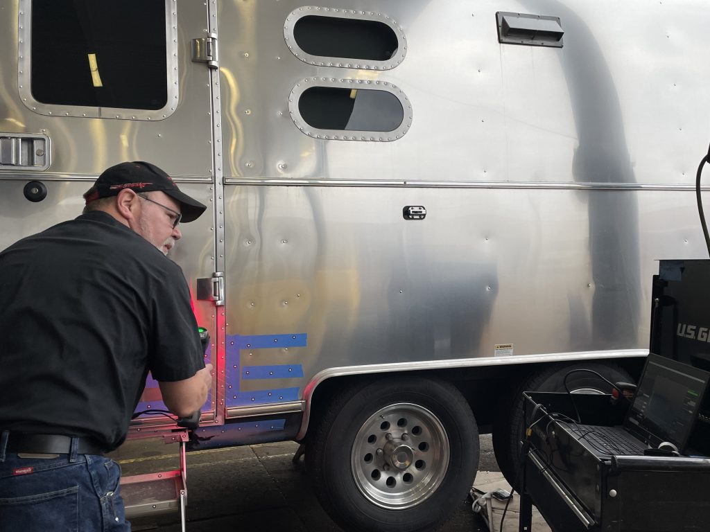 A person standing next to a trailer

Description automatically generated