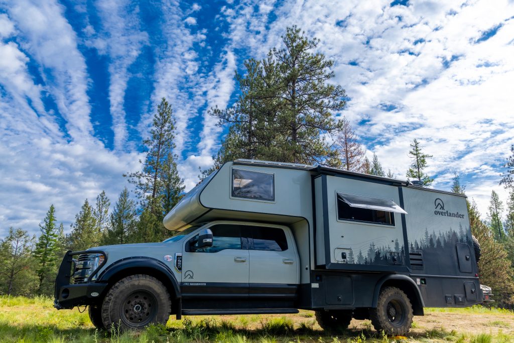 A truck with a camper on the side
Description automatically generated