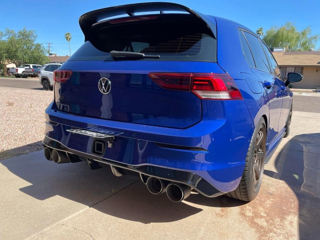 A blue car with its trunk open

Description automatically generated