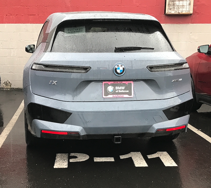 A back view of a car parked in a parking lot
Description automatically generated