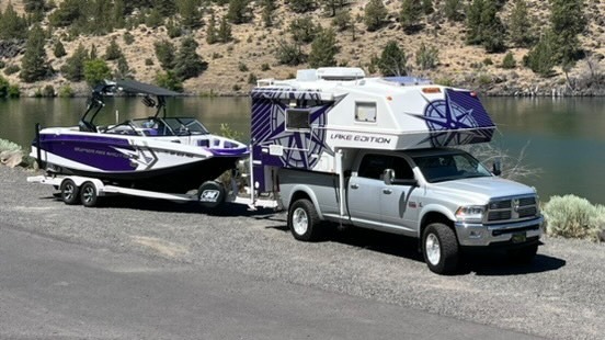 dodge pick up truck hauling truck camper and towing boat